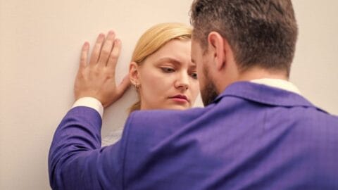 Awareness of Sexual Harassment in the Workplace for Employees online course: man leaning in towards a woman standing against a wall