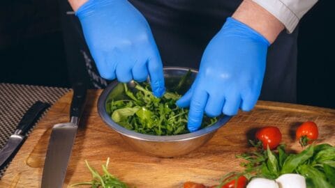 Food Safety Level 2 online course: gloved hands preparing a fresh salad