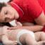 Paediatric First Aid online course: first aider checking a baby manikin for breathing
